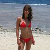 Секси девочка стоит в красном на пляже